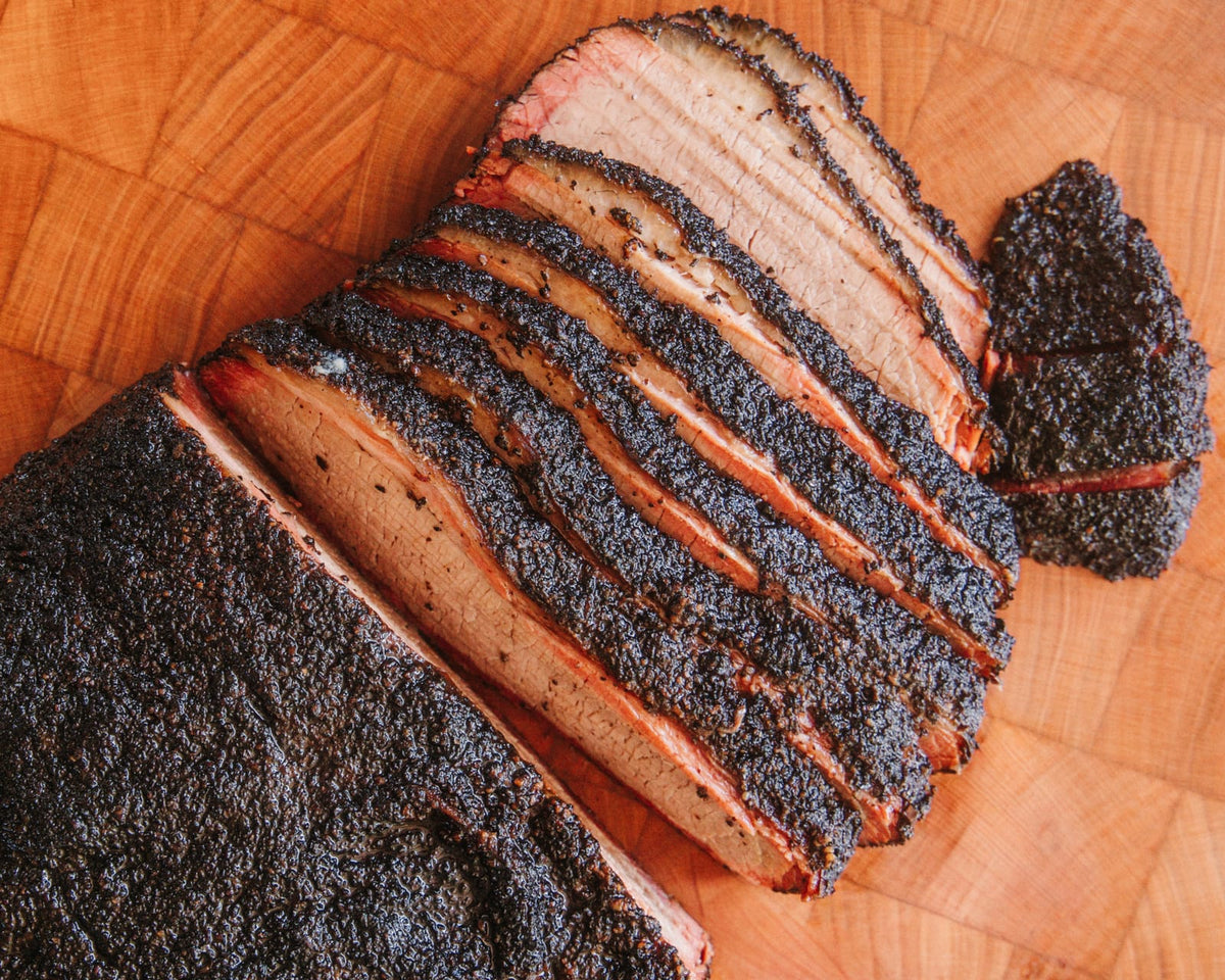 Whole smoked brisket sliced to show the smoke ring