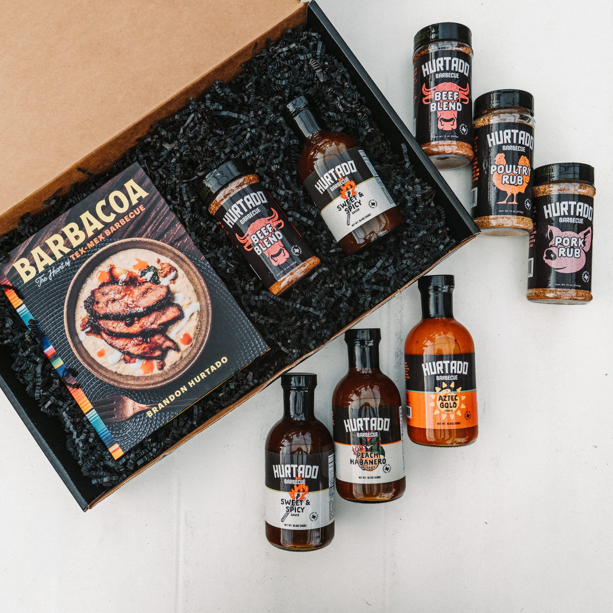The Cookbook Box open: the signed Barbacoa cookbook, a Hurtado rub and a sauce in the black gift box