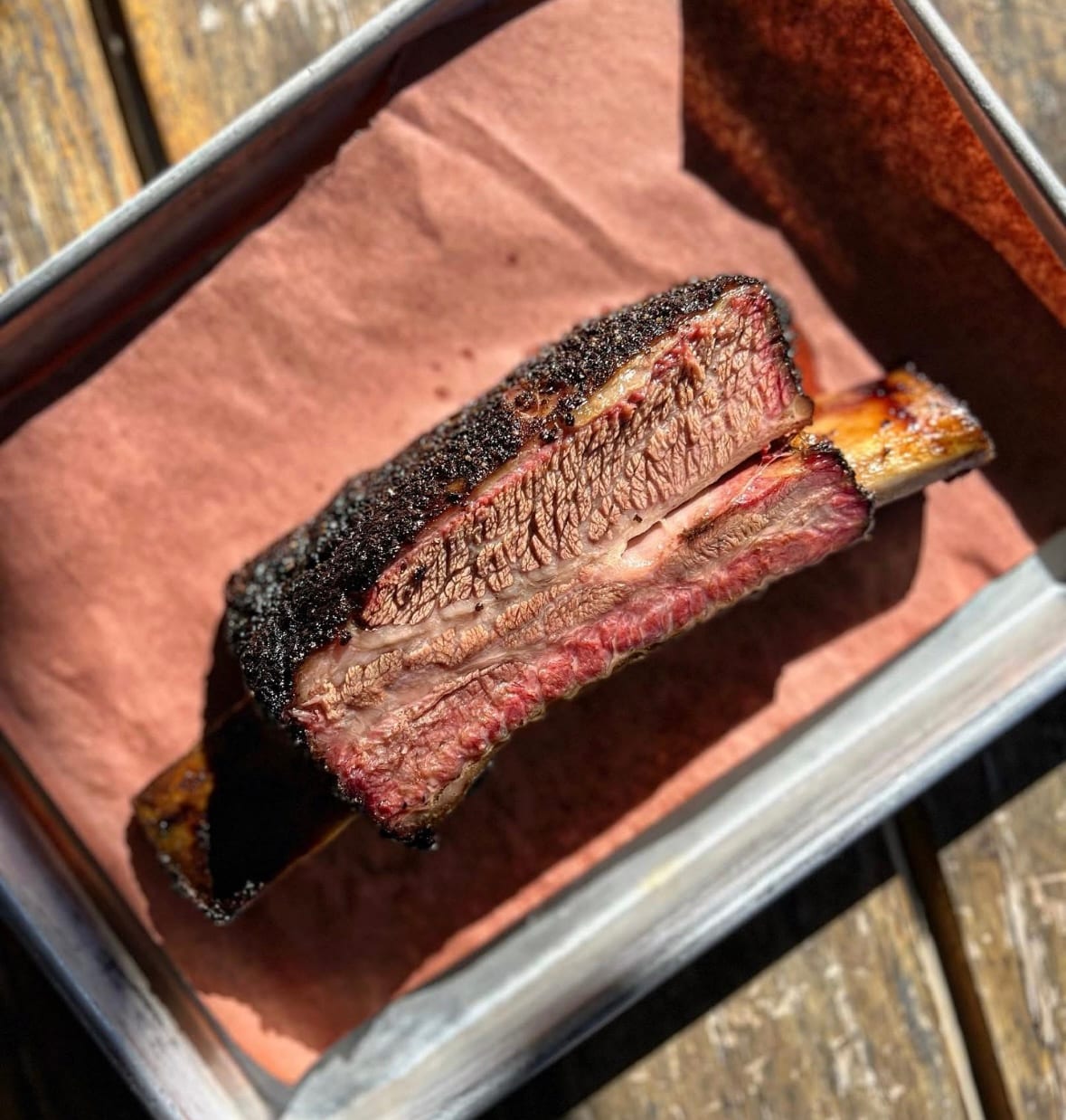 A beef rib sliced open to show the smoke ring